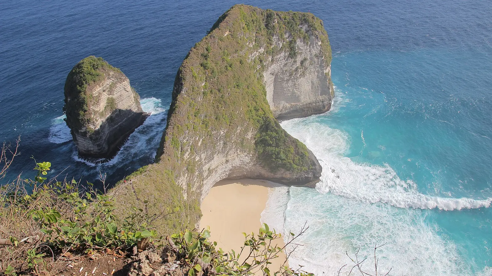 Nusa Penida cliff beach in Bali with turquoise water below steep rock walls