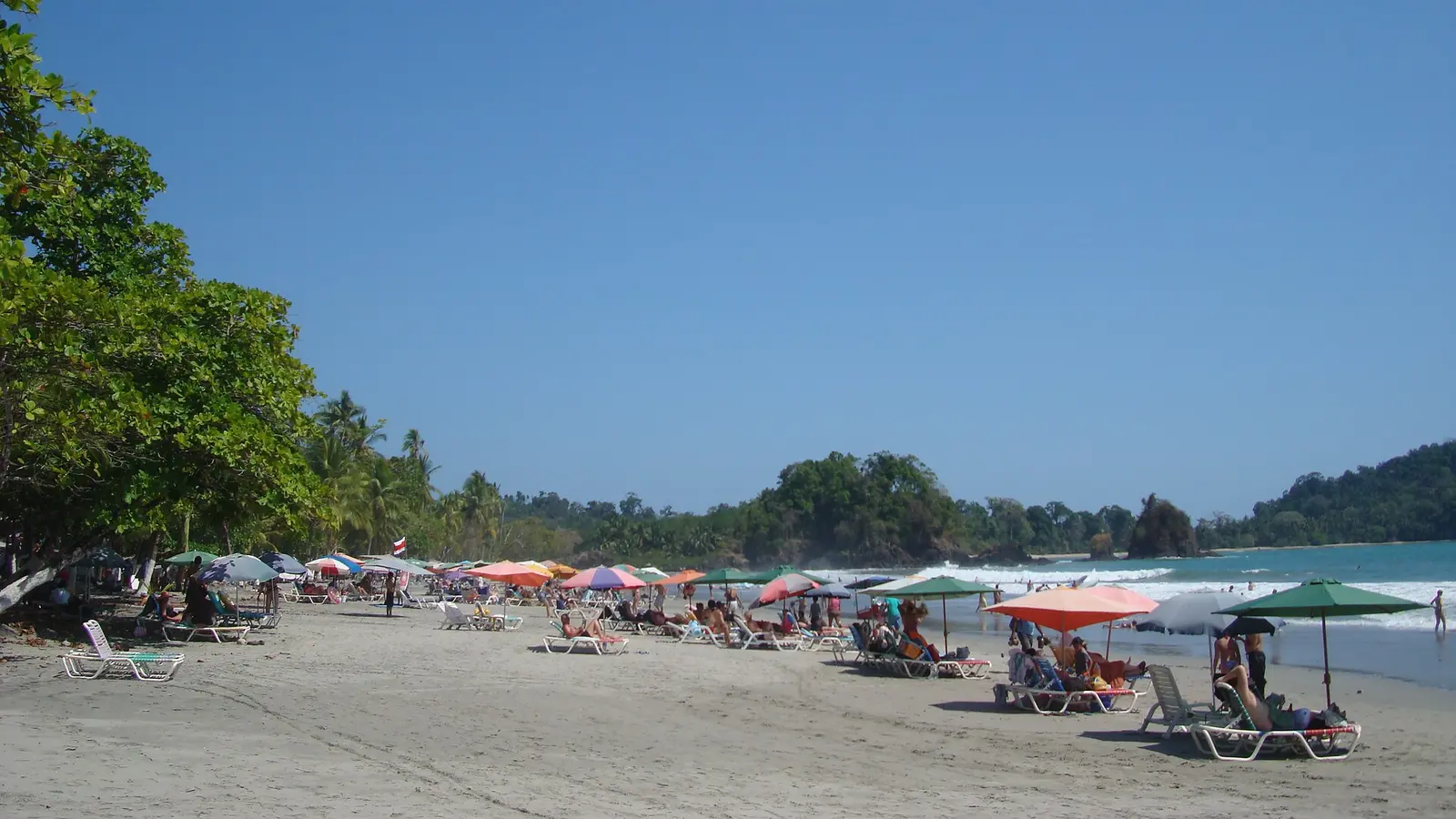 Manuel Antonio beach in Costa Rica with forest, umbrellas, and Pacific water